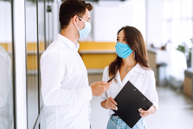 Business people with face mask working in the office. The concept of preventing the spread of the epidemic.