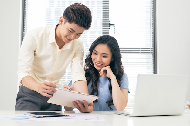 Business people working with computer and doing some paperwork while sitting at desk