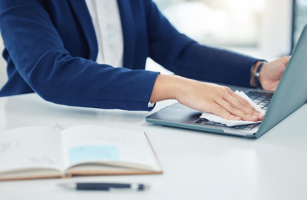 Business person clean laptop with tissue care for desk and workspace and protect from covid at table in corporate office Employee worker and professional cleaning dust from keyboard at work