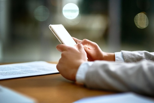 Photo business person hands and typing with phone at night for online browsing research or news at office desk closeup of employee working late on mobile smartphone web search or app in communication