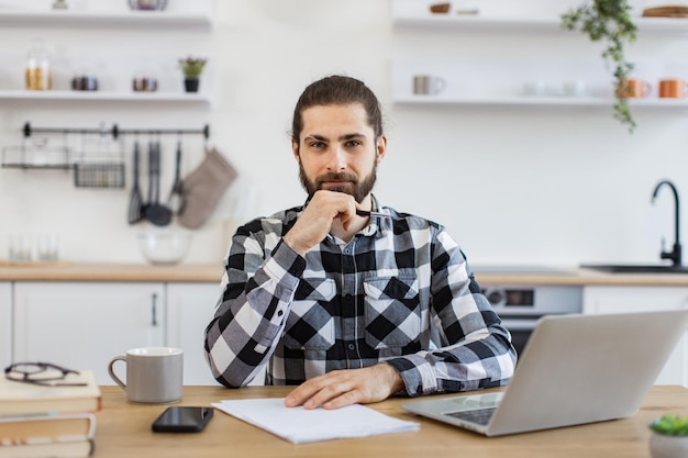 Business person posing with pen documents and portable computer