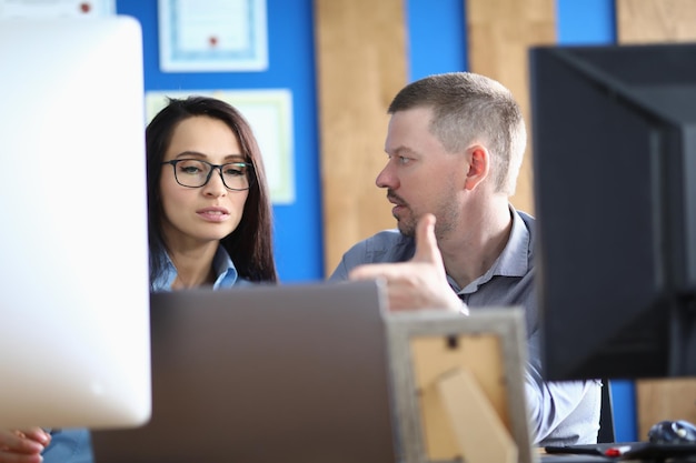 Business persons communicate in office at workplace in front of computer