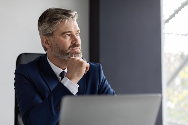 Business Planning Portrait Of Thoughtful Mature Businessman At Workplace In Office