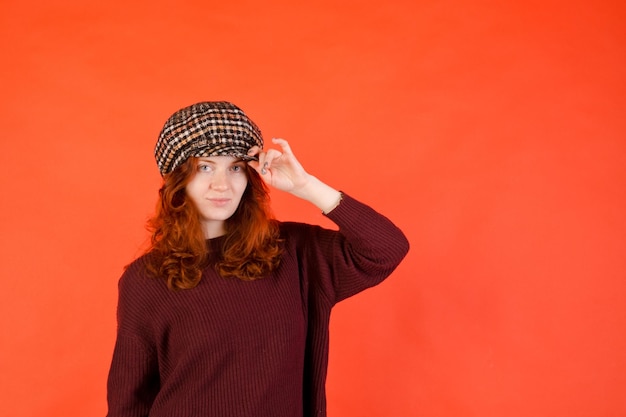 Photo business portrait of young woman with red curly hair mobile phone red background drinking coffee