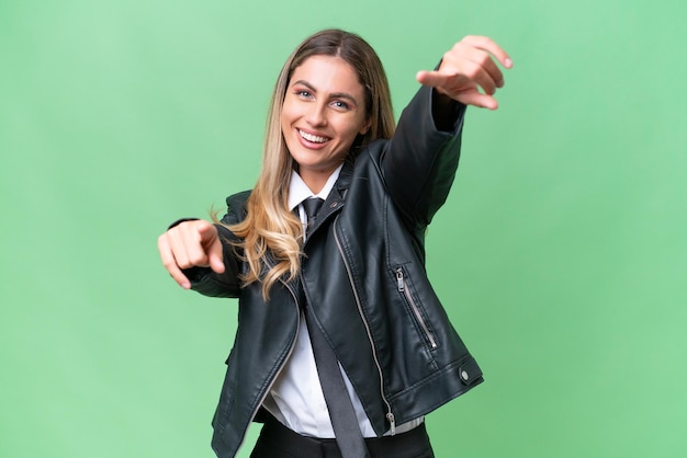 Business pretty Uruguayan woman wearing a biker jacket over isolated background points finger at you while smiling