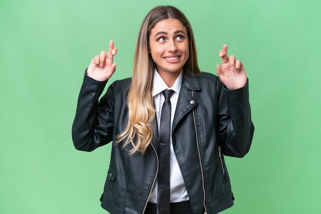 Business pretty Uruguayan woman wearing a biker jacket over isolated background with fingers crossing