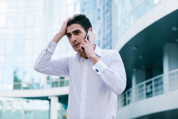 Business problems. disturbing phone call. financial disaster. corporate man getting bad news. clutching his head. financial disaster. career crisis