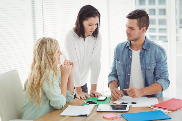 Business professionals discussing at desk 