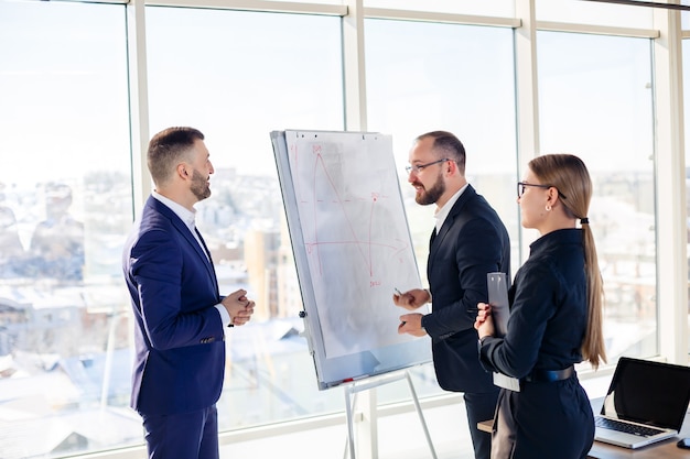 Business professionals. A group of young successful business people are analyzing data using graphs while spending time in a new modern office.