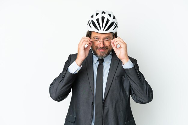 Business senior man with a bike helmet isolated on white background with glasses and surprised