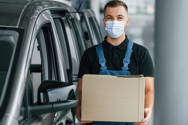 Business of service Delivery man in uniform is indoors with car and with order