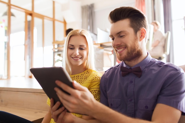 business, startup and people concept - happy creative team with tablet pc computer in office