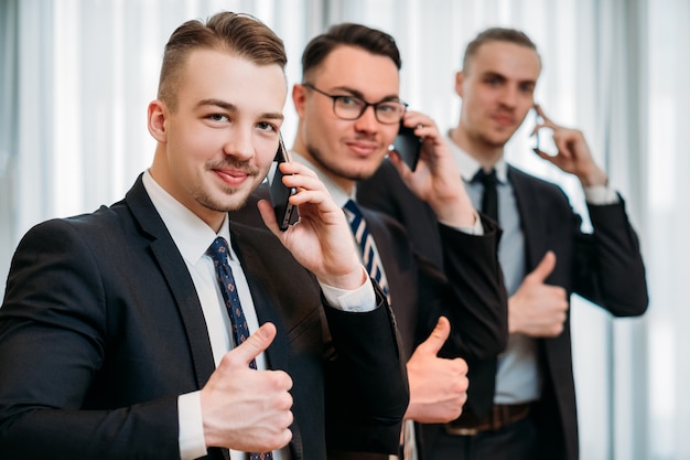 business success. Men in suits gesturing thumbs up