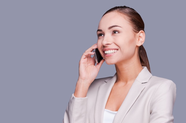 Business talk. Beautiful young businesswoman talking on the mobile phone and smiling