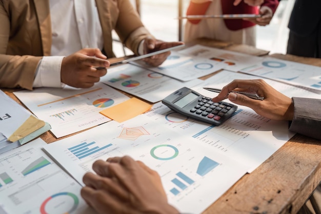 Business team analyzing income charts and graphs with calculator and tablet Close up Business analysis and strategy concept