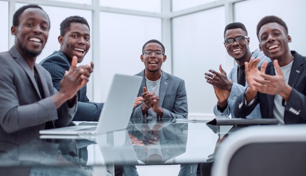 Business team applauds sitting at the office Desk