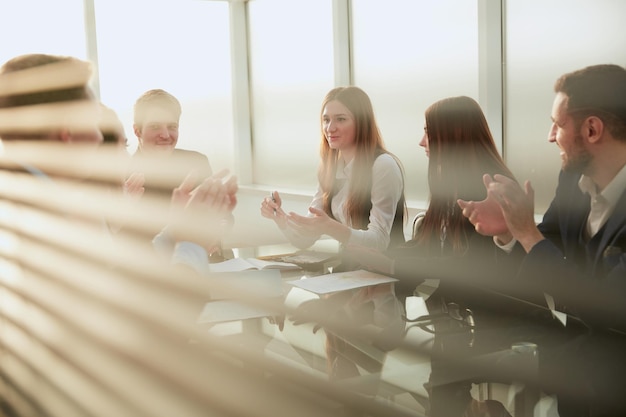 Business team applauds sitting at the office table