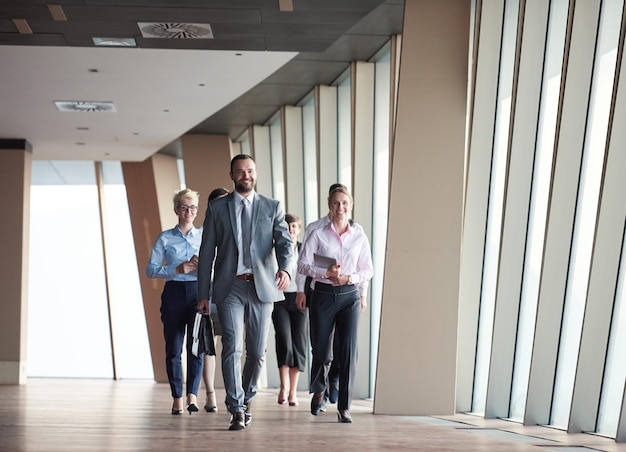 business team, businesspeople  group walking at modern bright office interior