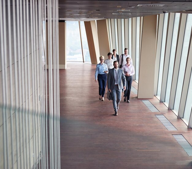 business team, businesspeople  group walking at modern bright office interior