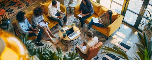 Photo business team collaborating on project in coworking space surrounded by natural elements including a green plant round wooden table and large glass window with a man in a white shirt