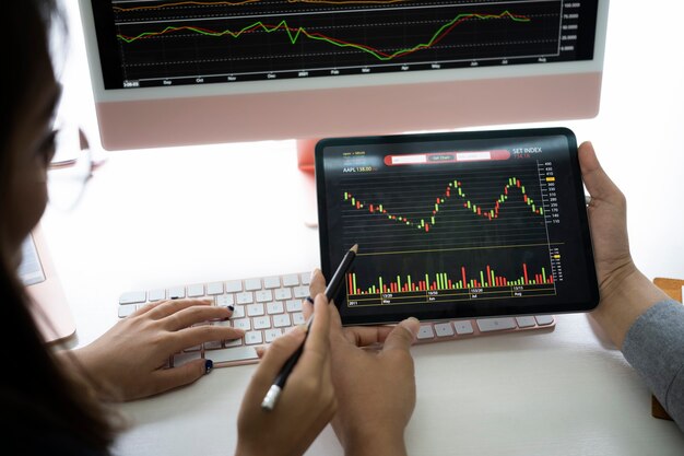 Business team discussing and analyzing graph stock market  trading with digital tablet.