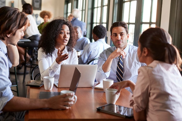 Business Team Having Informal Meeting Around Table In Coffee Shop