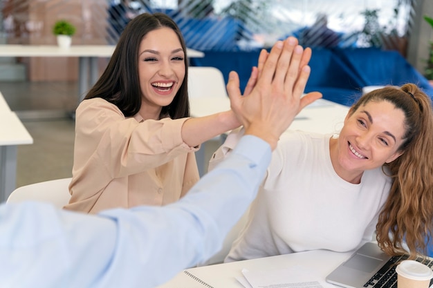 Business team high-fiving each other in the office for great work results