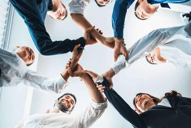 Business team joining hand in circular together symbolize successful group of business partnership and strong collective unity teamwork in diverse culture community workplace Prudent