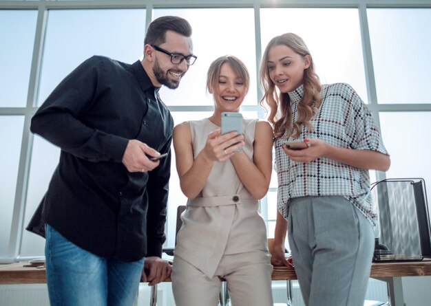 Business team looking at the screens of their smartphones