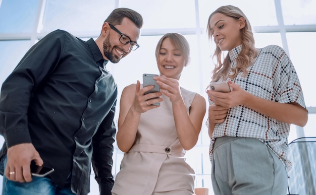 Business team looking at the screens of their smartphones