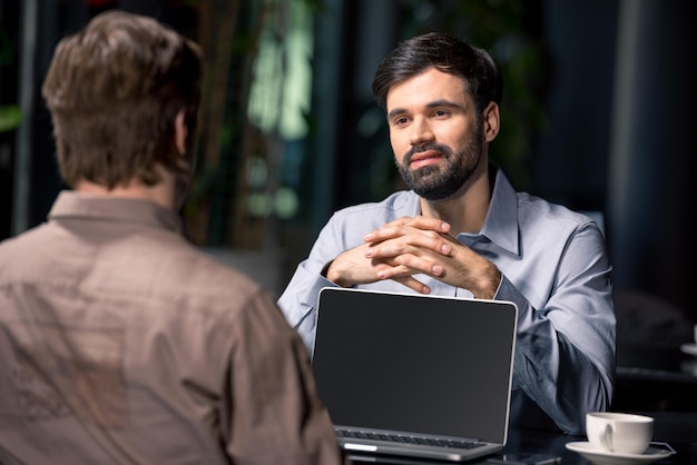 Business team on meeting discussing project with laptop in cafe, business lunch concept