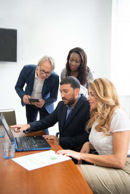 Business team of men and women in an office analyzing the evolution of the company