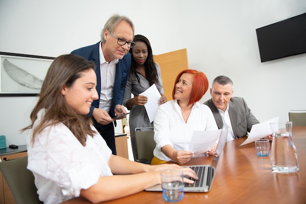 Business team of men and women in an office analyzing the evolution of the company