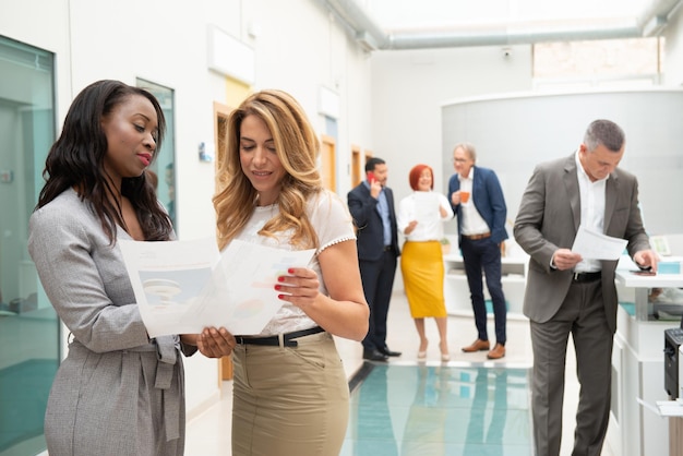 Business team of men and women in an office analyzing the evolution of the company