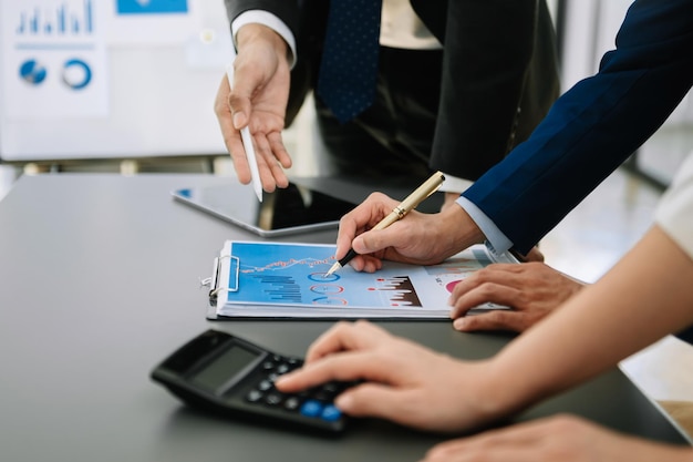 Business team on office table with smart phone and calculator digital tablet and graph business with social network diagram and two colleagues discussing data working in the office