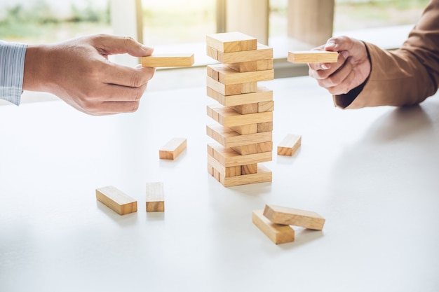 business team playing the wood game, hands of executive cooperation placing wood block