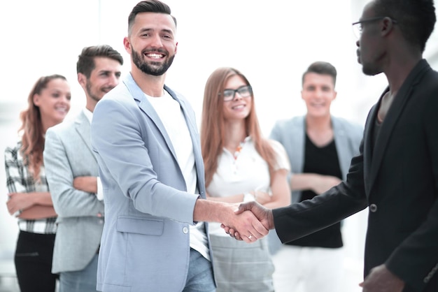 Business team of several people mens shaking hands and smiling