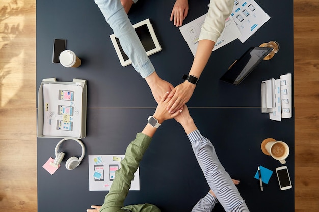 Photo business team stacking hands at office table