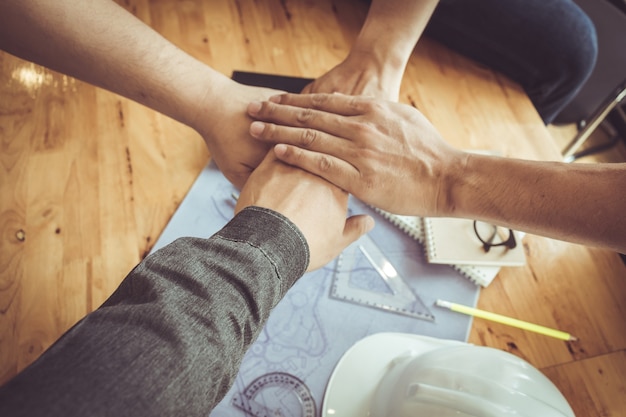 Business team standing hands together in office, construction engineer