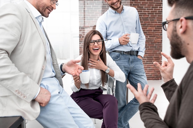 Business team talking and smiling during coffee break in office