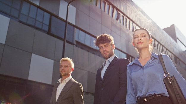 Business team walking together on downtown street confident people look camera