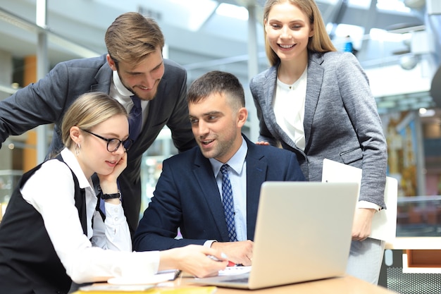 Business team working on laptop to check the results of their work.