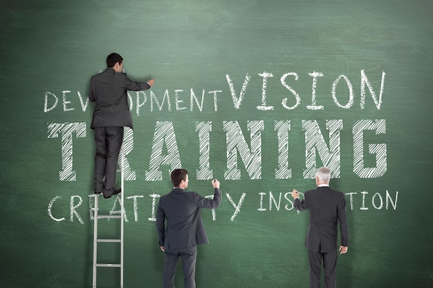 Photo business team writing against green chalkboard