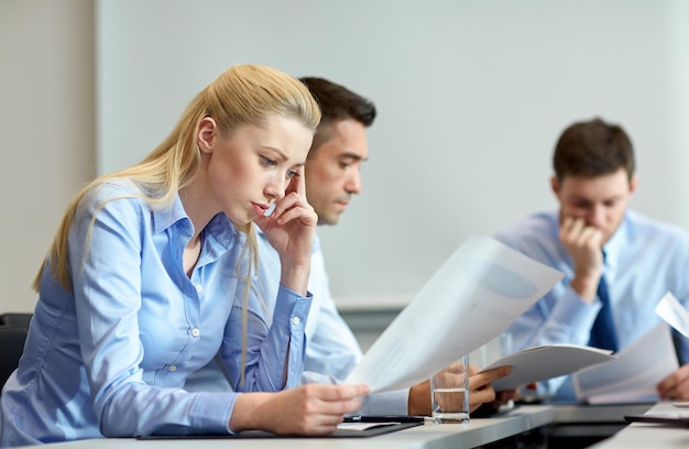 business, teamwork, people and crisis concept - business team sitting sad and solving problem in office