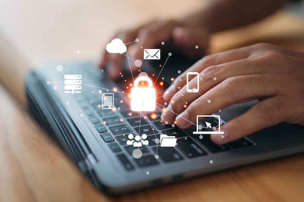 Business technology internet and networking concepts A young businessman working on his laptop in the office selects the security icon on the virtual display