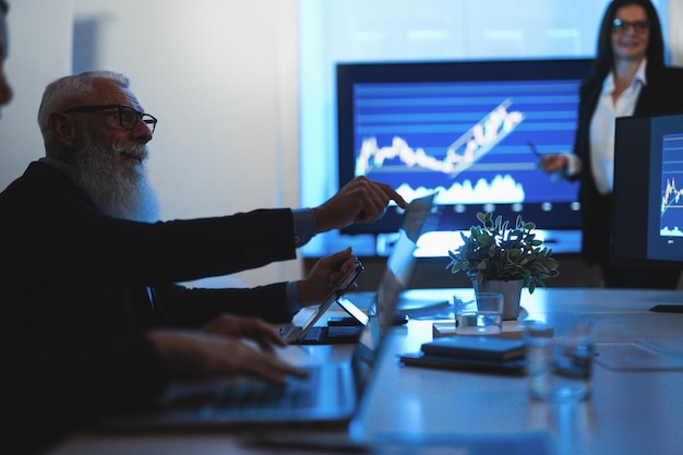 Business trader team doing stock market analysis inside hedge fund office  Focus on senior man face