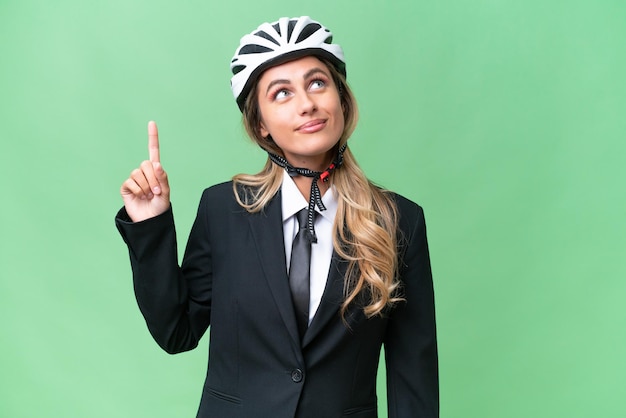 Business Uruguayan woman wearing a helmet biker over isolated background pointing up and surprised