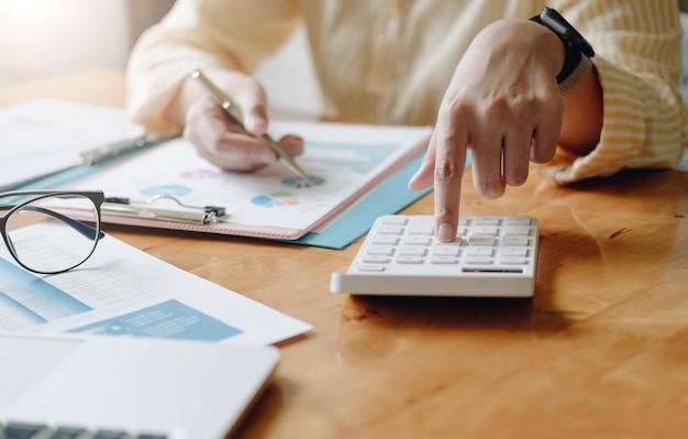 Business woman accountant making working audit and calculating expense financial annual financial report balance sheet statement, doing finance making notes on paper checking inspection.