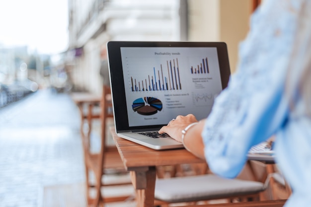 business woman analyzing financial data sitting at a table in a cafe