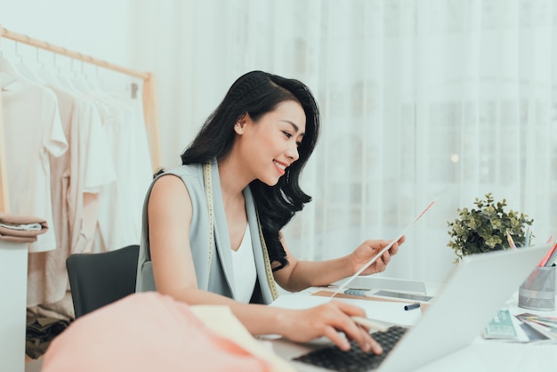 A business woman / Asian fashion designer working at her office / workshop